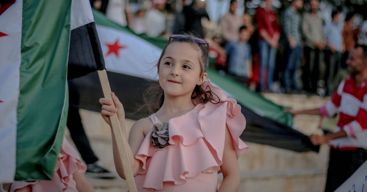 Syrian girl holding Syrian flag.