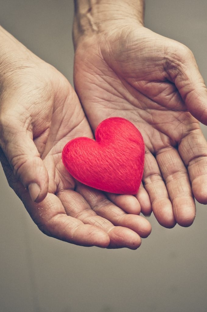 Hands giving a heart to represent charitable giving