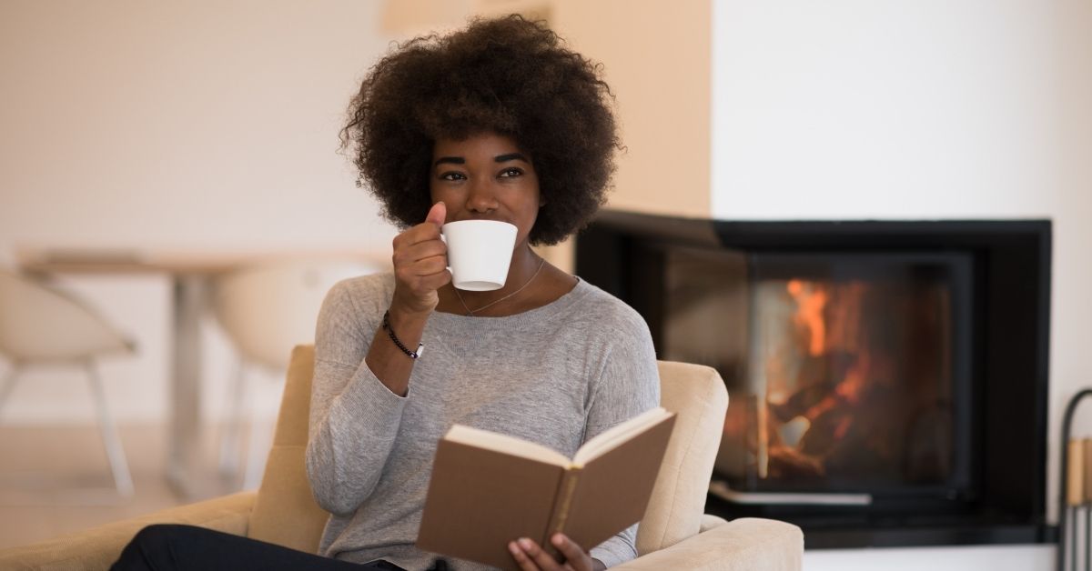 A woman relaxing with a book and tea.
